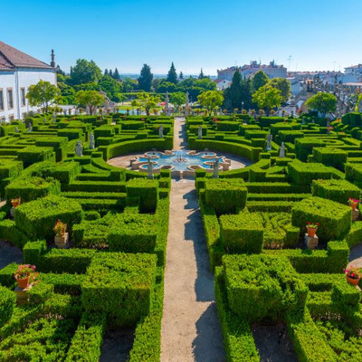 The garden Jardim do Paço Episcopal with green hedges that form a labyrinth with a water fountain in the centre.