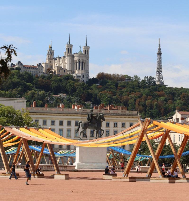 Place Bellecour in Lyon with the statue of Louis XIV, the Basilica of Fourvière and the metal tower in the background