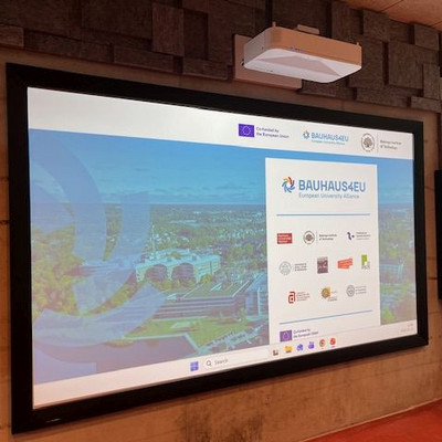 A large screen in the room displays the BAUHAUS4EU European University Alliance welcome slide.