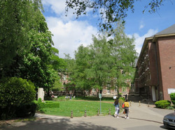 Students in a green outdoor area with trees in front of the Pôle Saint-Charles building in Amiens, France